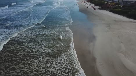 Flying-over-aerial-shot-in-the-Atlantic-ocean-beach-with-big-waves-and-clouds,-summertime-beach-in-Brazil