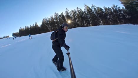 vista de cámara de acción frontal de un snowboarder de alta velocidad con palo selfie por la noche, 60 fps