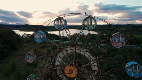 Abandoned-amusement-Park-Kejonuma-Leisure-Land-Ferris-Wheel-Aerial-Drone,-Japan-Sunset-Colorful-Skyline,-overground-fields-in-forgotten-Japanese-Location