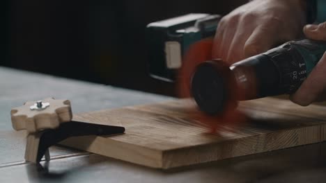 carpenter uses electric screwdriver with abrasive nylon brush, brushing wood in slow motion, woodworking at workshop, 4k 60p prores 422 hq 10 bit