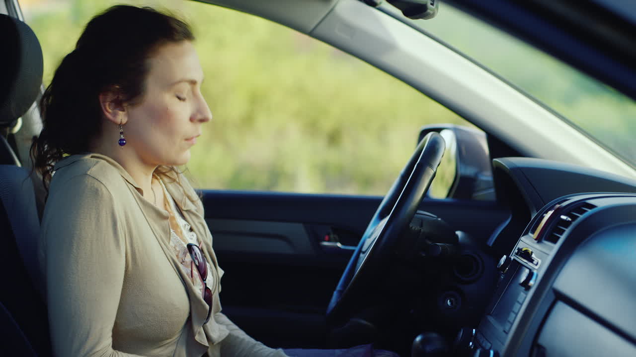 una mujer frustrada con un teléfono se sienta en el auto