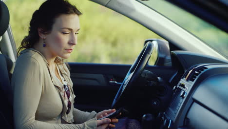 una mujer frustrada con un teléfono se sienta en el auto