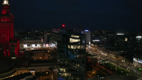 Ascending-shot-of-night-city.-Various-buildings-in-city-centre-and-traffic-in-streets.-Warsaw,-Poland