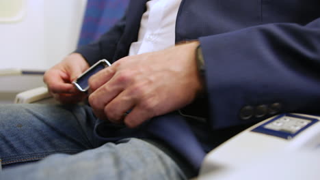 close up of a man buckling and fastening seat belt on a passenger plane airliner airplane seat