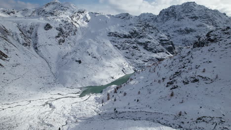 fly over delta of a glacier river in the alps from a drone in winter on a sunny day, italy