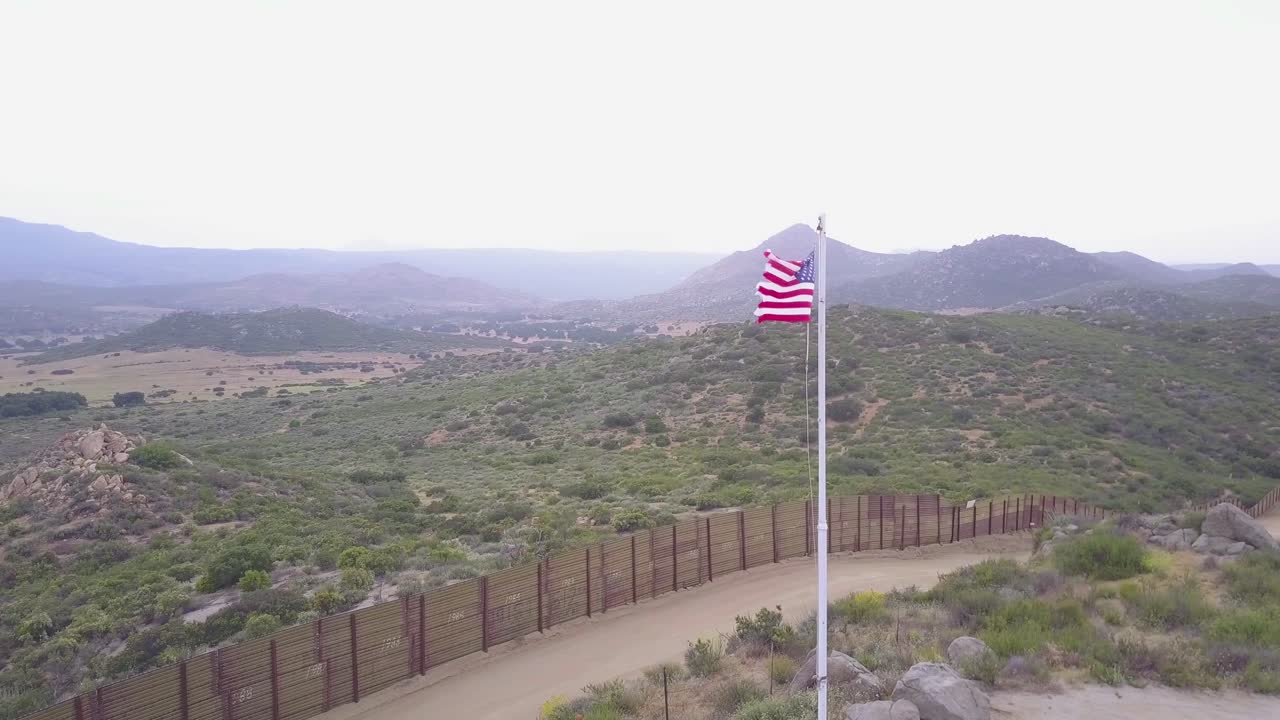 la bandera estadounidense ondea sobre el muro fronterizo de estados unidos y méxico en el desierto de california 2