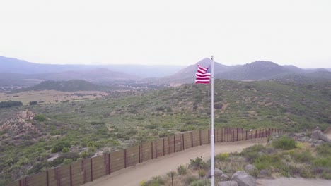 the american flag flies over the us mexico border wall in the california desert 2