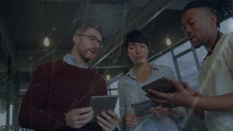 animation of network of connections over diverse colleagues discussing over digital tablet at office