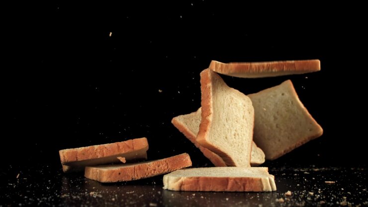 Slices of White Bread Falling in Slow Motion on Black Background
