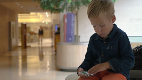 Child-flipping-photos-on-cell-in-trade-centre