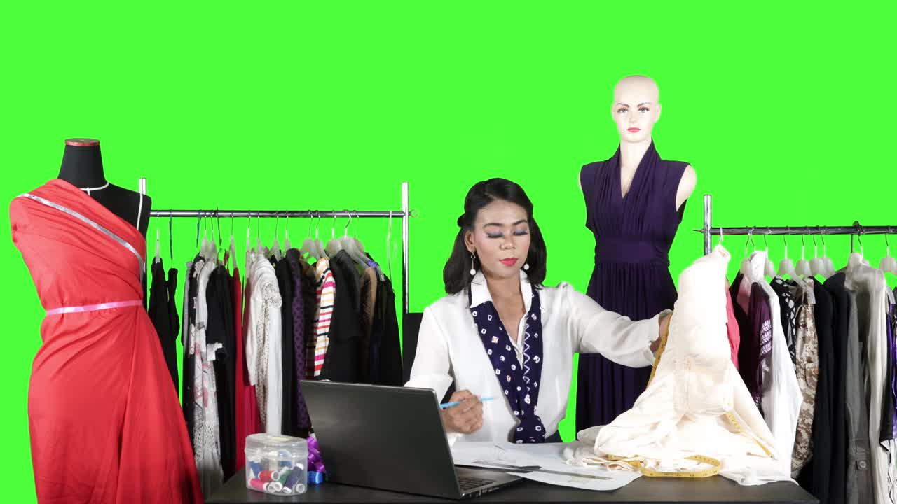 디자이너가 옷을 측정하는 데 측정 테이프를 사용합니다.