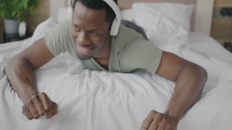 man listening to music in bed