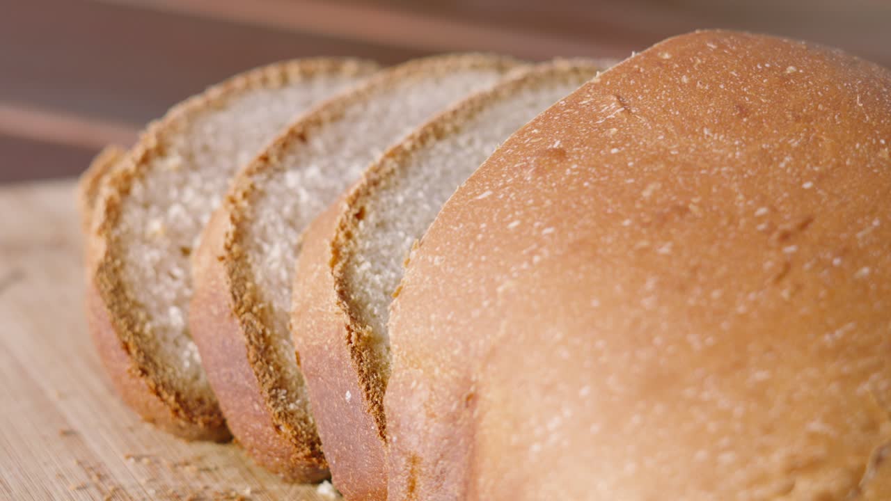 Freshly Baked Homemade White Bread with Slices on Wooden Chopping Board Outside in Natural Morning Sunlight with Shallow DOF. Home Baking Footage with Simple Healthy Ingedients 4K.