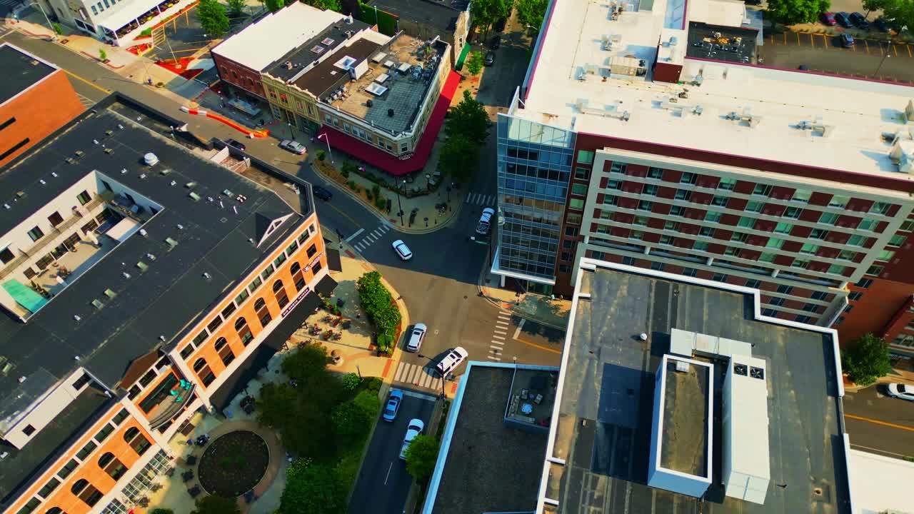 Una ripresa aerea di un vivace incrocio urbano a Champaign, Illinois, con auto, pedoni ed edifici che mostrano architetture moderne e classiche