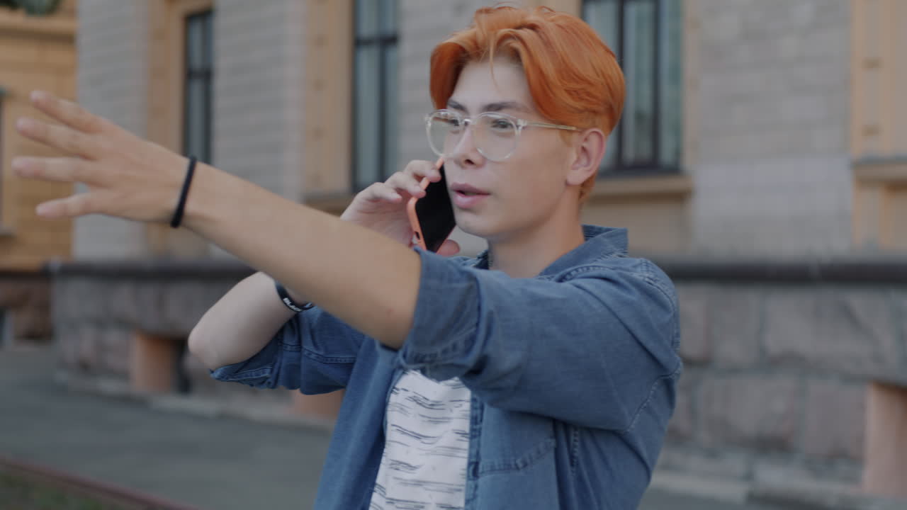 밖에서 전화로 얘기하는 젊은 남자