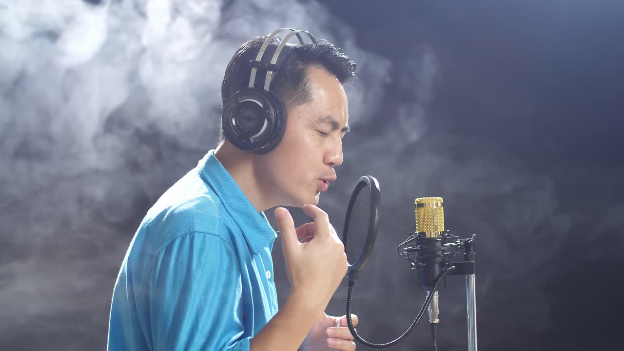 녹음 스튜디오 에서 마이크 로 노래 하는 남자