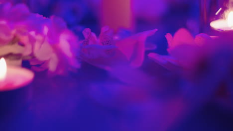 composición azul y violeta con velas y flores