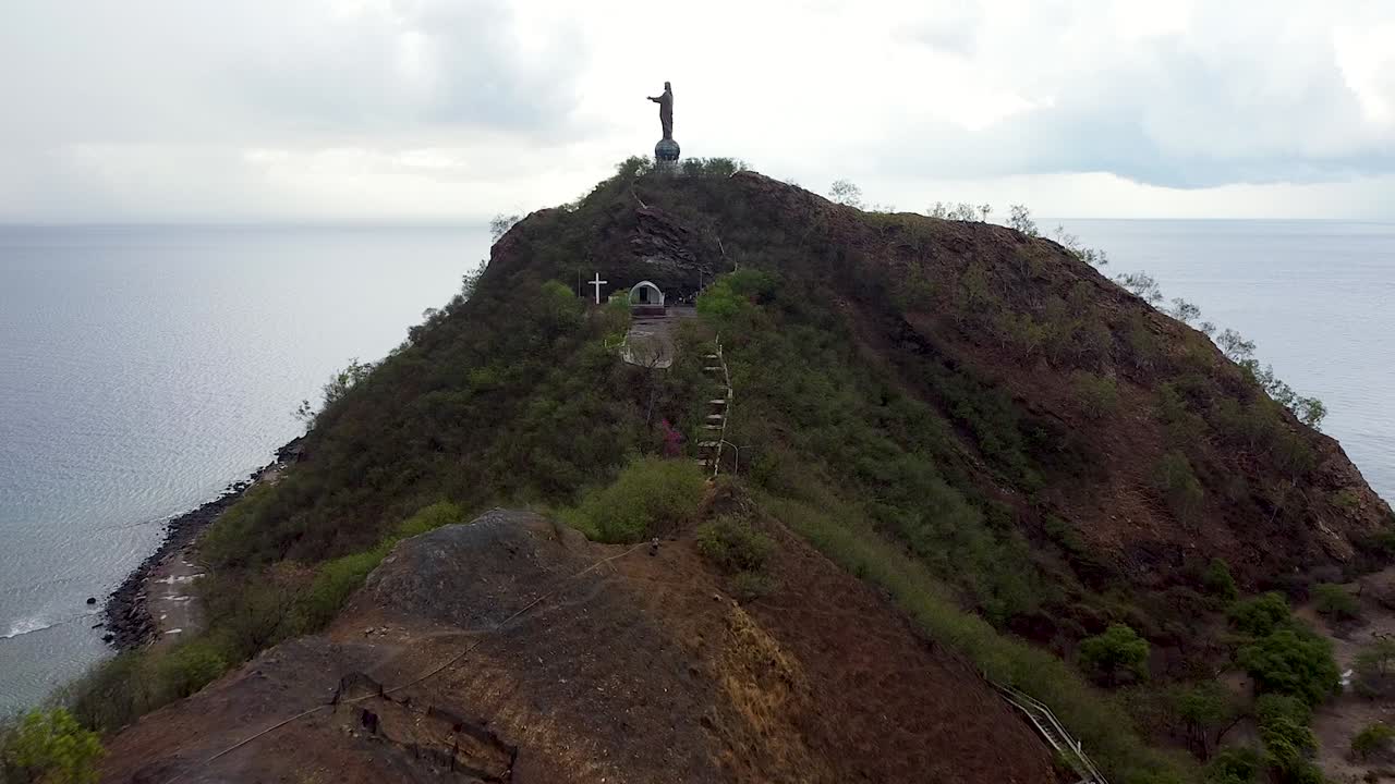 Aerial flying towards Cristo Rei statue landmark in capital city of Dili, Timor-Leste, Southeast Asia