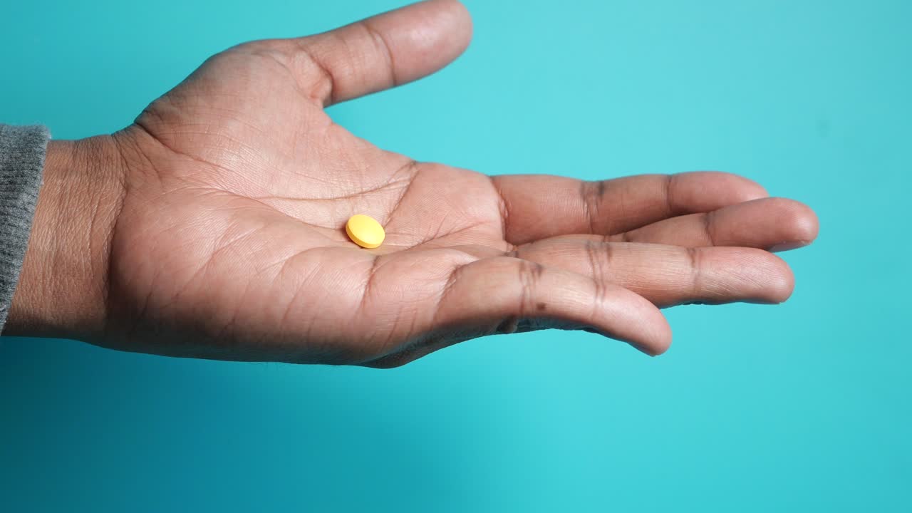 píldora amarilla en la mano