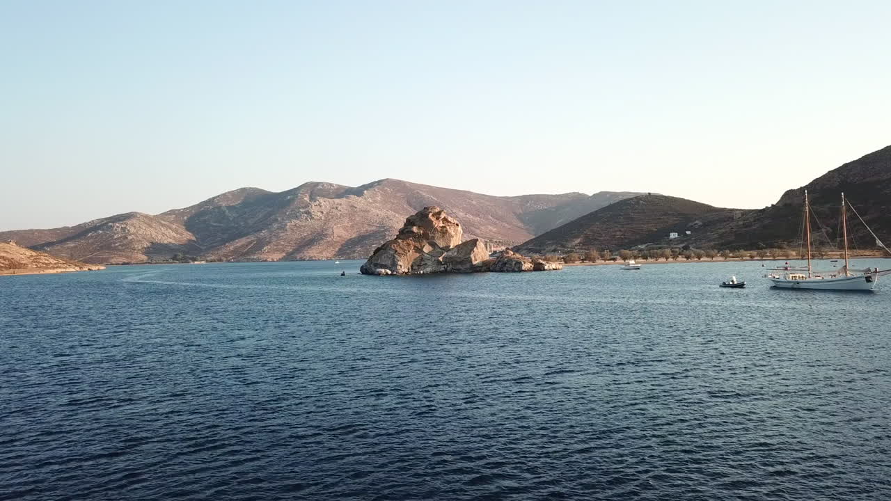 Greece, Patmos Island, Drone Footage of the holly rock of Kalikatsou. Famous Rock formation in mythology at the Grikos Bay. Centuries of worship. Picturesque island with beautiful landscapes.