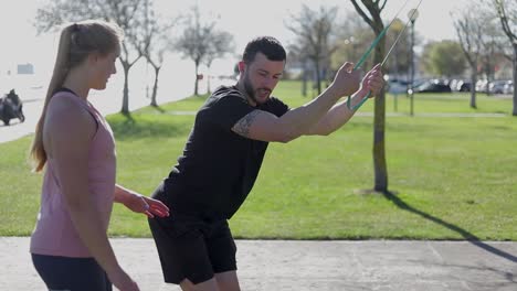 un hombre moreno pensativo y una mujer rubia entrenando en el parque de verano.