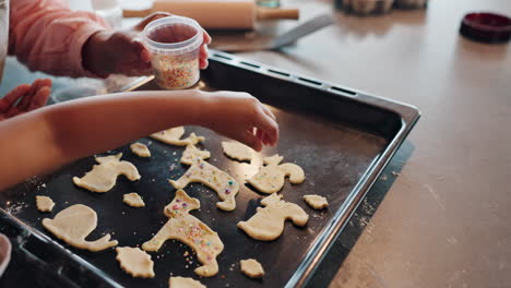 child baking cookies with sprinkles
