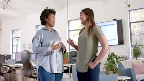 happy diverse business female colleagues in discussion in casual office meeting, slow motion