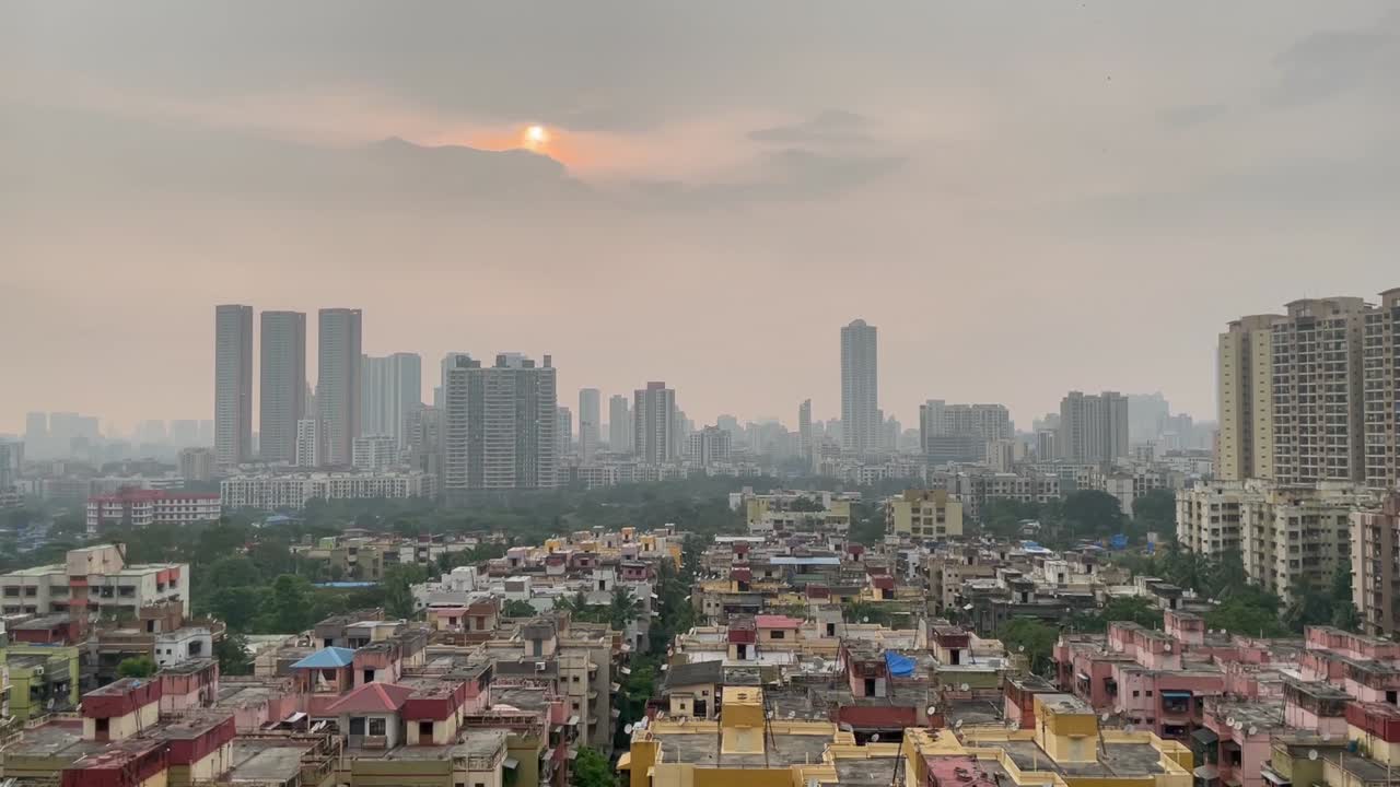 Ripresa aerea con lenta inclinazione verso l'alto della città di Thane durante il tramonto, India.