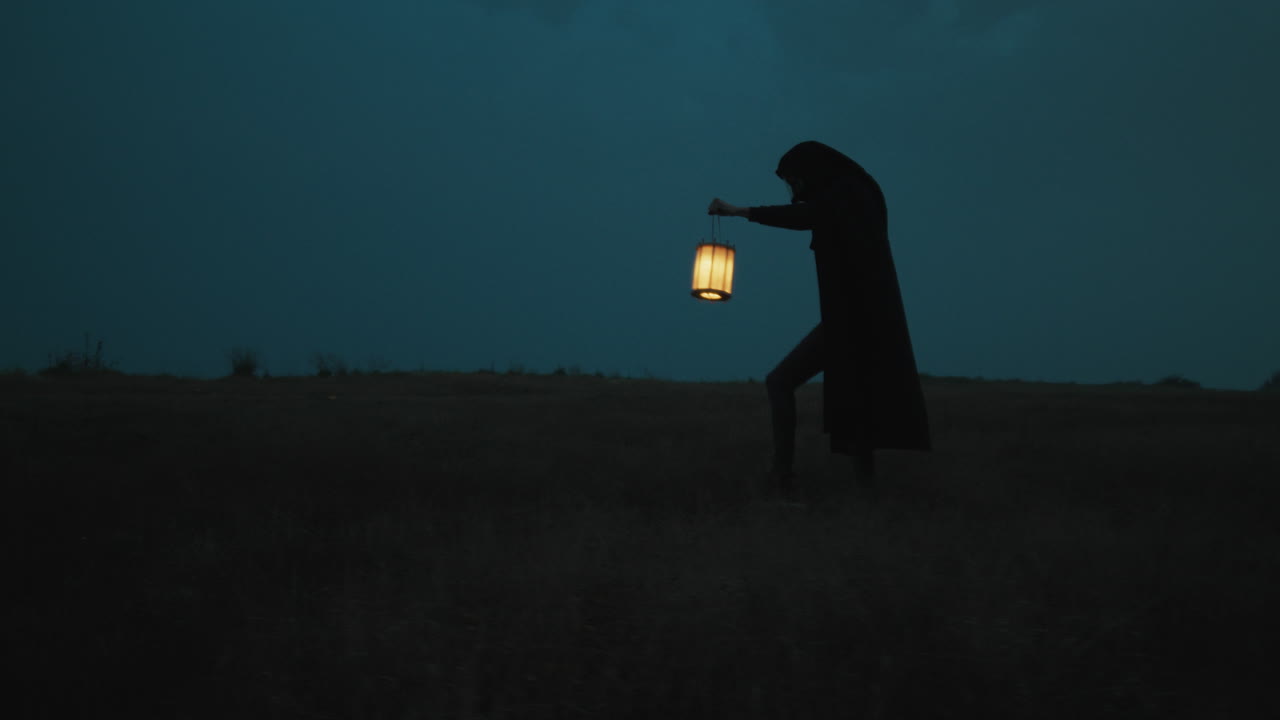 Halloween Night Mysterious Silhouette Of A Cloak Man Searches With Lantern