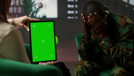 black army soldier crying at therapy session next to chroma key screen