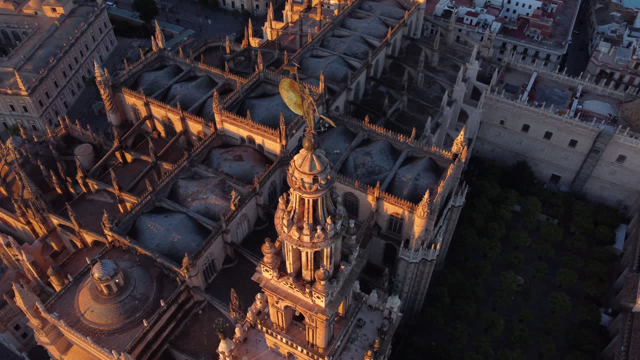 Aerial rotation around the top Giralda tower of the largest gothic cathedral in the world in Seville, Spain