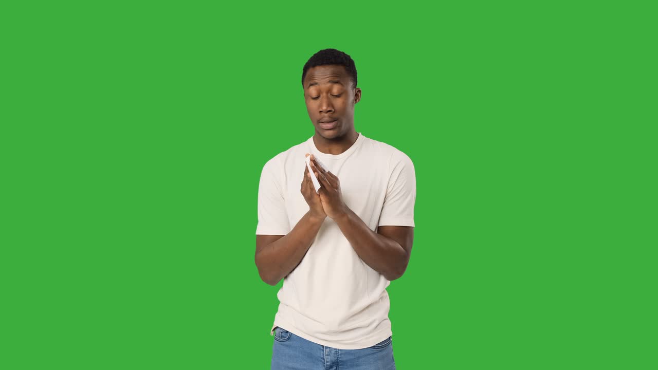 Man sneezing in tissue paper and wiping runny nose