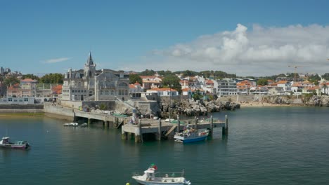 Aerial-Dolly-motion-Cascais-bay-seaside,-Seixas-Palace-and-beach-shore