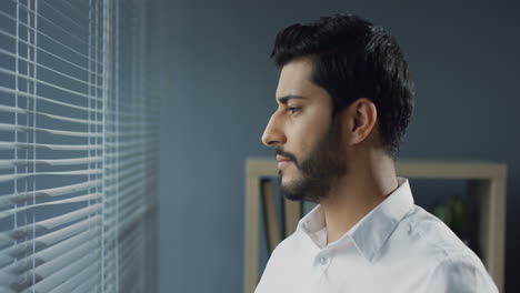 close up view of arabian businessman looking out the window and then looking to the camera