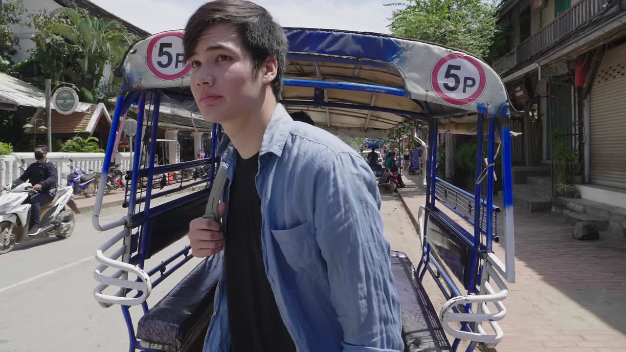 Tourist experiences a Tuk Tuk ride in Luang Prabang, Laos.