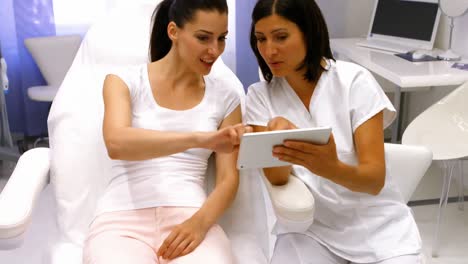 doctor and female patient discussing on digital tablet