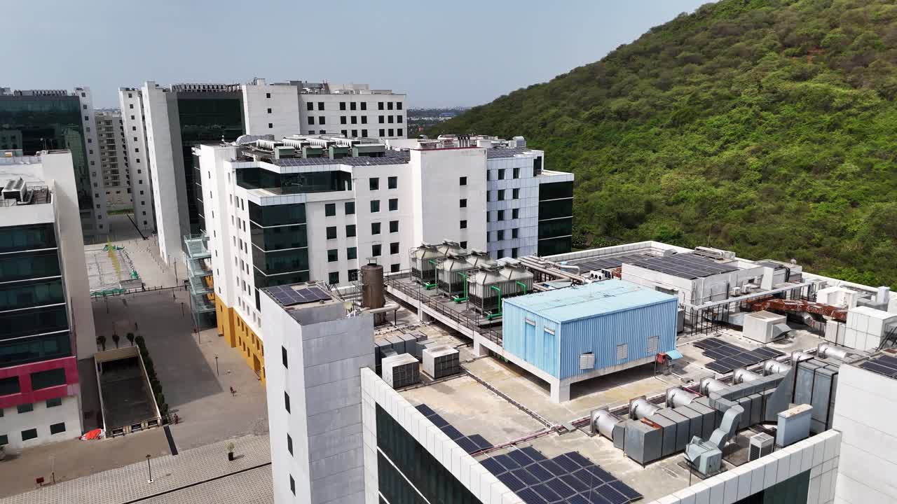 Close-up shot of contemporary office buildings with contrasting facades: white blocks, reflective glass one building of a business campus. The shot emphasizes the large-scale solar power installation