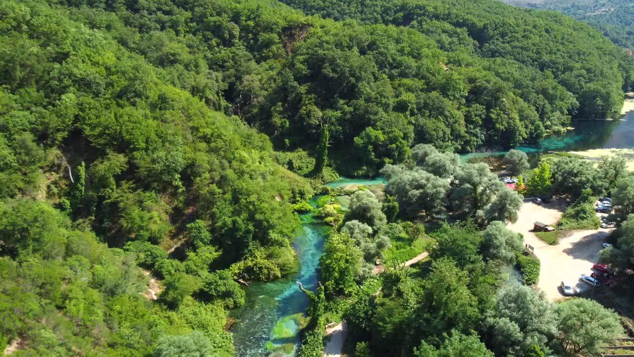 Drone shot of the Blue Eye in Albania - drone is ascending and panning down, revealing its beautiful colours and clear water