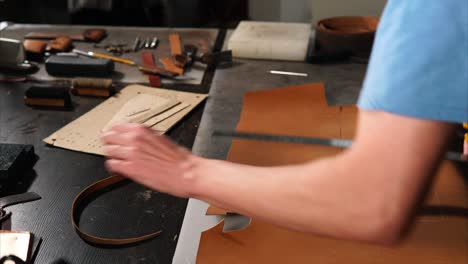 leather craftsman cutting leather