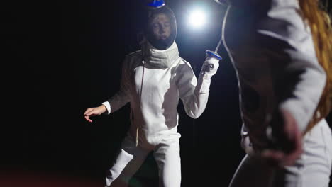 a female fencer in action, wearing a white uniform and mask, holding a sword.