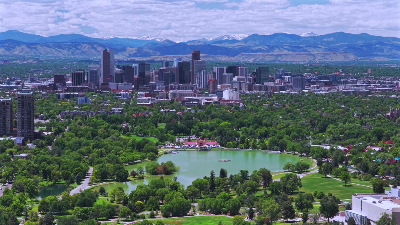 Toàn cảnh từ drone Công viên Thành phố Denver, Colorado, với Nhà triển lãm, các tòa nhà chọc trời, Hồ Ferril, vào buổi sáng mùa xuân dưới bầu trời xanh, cùng với đường đi bộ trong khu dân cư và cảnh quan đô thị nhìn xuống.