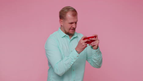 worried funny addicted tourist guy enthusiastically playing drive racing video games on mobile phone
