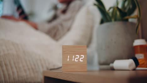 a person is sleeping in bed with medicine on a bedside table