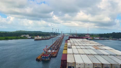 view from the bow of a massive container ship as it navigates through the industrial lock system of the panama canal, a critical waterway for global shipping and commerce