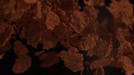 Cereal-flakes-bouncing-against-black-background