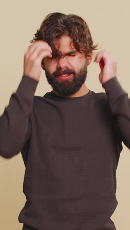 lebanese bearded man in long sleeves rubbing temples to cure headache problem on beige background