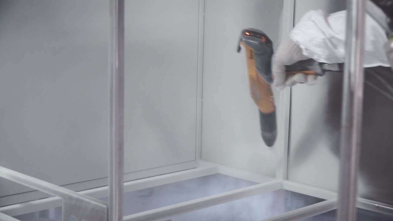 recubrimiento en polvo de marcos metálicos en una cabina de pintura