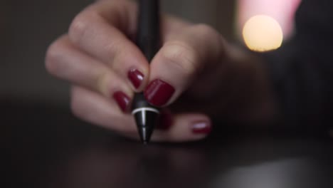 slow motion: detail of digital pen in a womans hand on modern graphic tablet