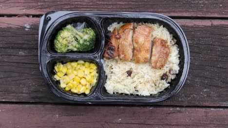 Curry-chicken-and-rice-in-a-take-away-plastic-packet-on-table