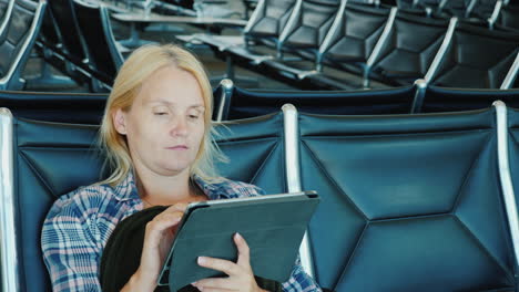 A Woman Uses A Tablet In An Airport Lounge Leisure Pending Flight